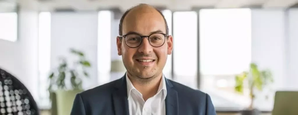 Mr Grimm, Dürr Consulting wants to increase digital know-how through excellent partnership and presents this standing confidently in a factory hall.