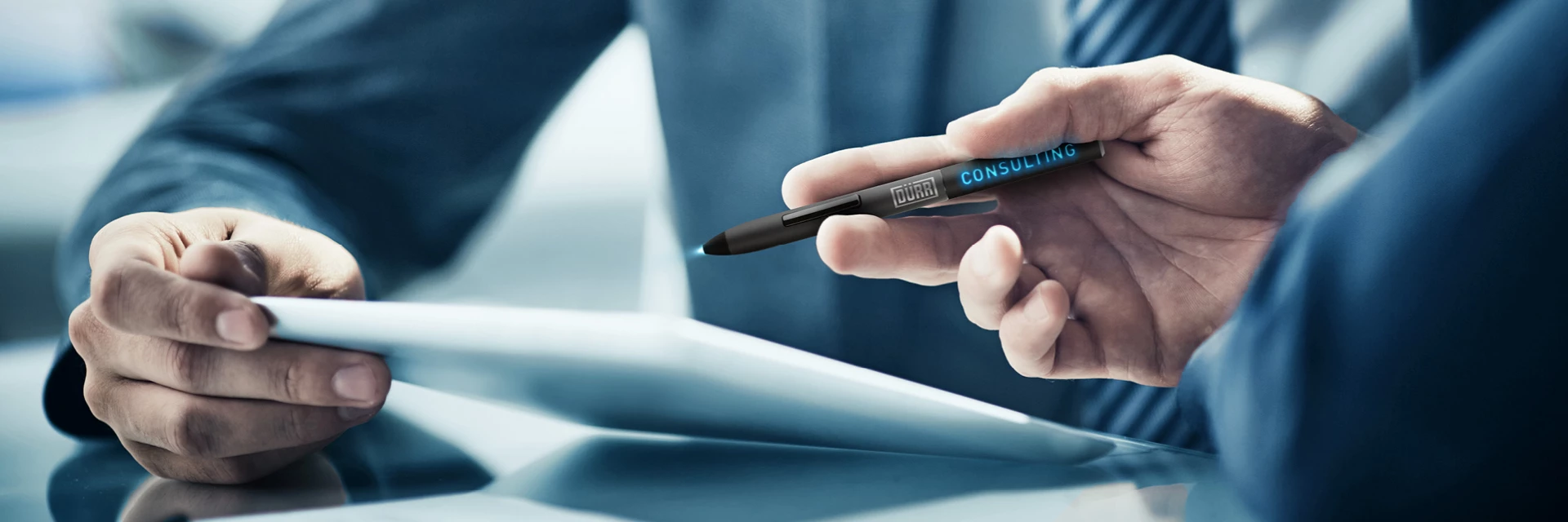 duerr-consulting-expertsDürr Consulting's consulting services represented by a hand holding a tablet pen with the Dürr Consulting logo illuminated. 