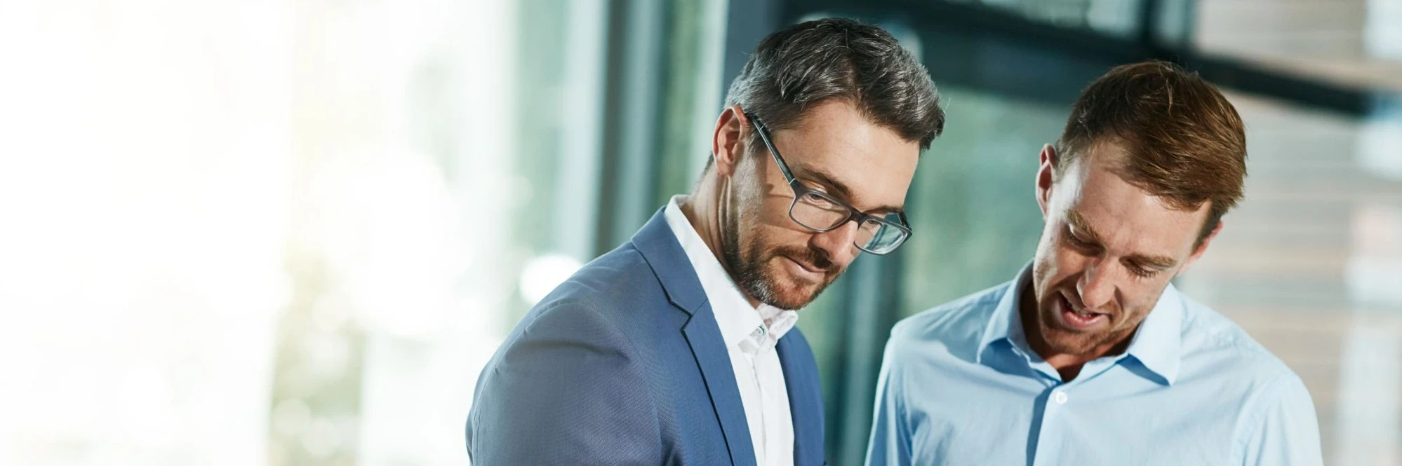 Dürr Consulting berät einen Fabrikplaner, zwei Männer schauen auf eine Unterlage